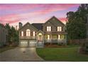 Two-story home with front porch at dusk, showcasing its curb appeal and inviting atmosphere at 113 Westchester Xing, Canton, GA 30115