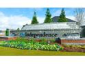 Stone community entrance sign for Independence neighborhood, landscaped with flowers, shrubs, and trees at 1149 Blue Juniper Cir, Loganville, GA 30052