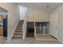 Welcoming foyer with staircase, neutral carpet, and paint, providing access to kitchen and living spaces at 4634 Garden Hills Dr, Stone Mountain, GA 30083