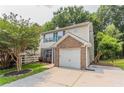 Two-story home with brick details, blue shutters, and attached one-car garage at 7070 Ravenwood Ln, Lithonia, GA 30038