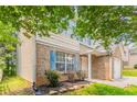 Two-story home with brick facade, blue shutters, and small landscaped yard at 7070 Ravenwood Ln, Lithonia, GA 30038