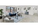 Bright living room with a blue velvet sofa, accent chairs, and large picture window at 1066 Cleavemark Dr, Clarkston, GA 30021