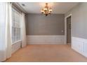 Inviting dining room featuring classic wainscoting, neutral walls, and a decorative light fixture at 939 Bendleton Dr, Woodstock, GA 30188