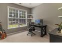 Comfortable home office with neutral walls, natural lighting, and custom shelving at 939 Bendleton Dr, Woodstock, GA 30188