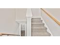 Carpeted staircase leading to the upper level with a wooden railing at 946 Redan Trce, Stone Mountain, GA 30088