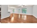 Open-concept living area with hardwood floors and natural light with kitchen area at 118 Hardy Water Dr, Lawrenceville, GA 30045