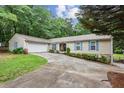 Charming home exterior with blue shutters, a two-car garage, a lush green lawn, and a driveway leading to the front entrance at 1185 Wedgefield Sw Dr, Marietta, GA 30064