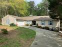 Inviting home exterior with a two-car garage, blue shutters, and a well-maintained front lawn with flowering shrubs at 1185 Wedgefield Sw Dr, Marietta, GA 30064