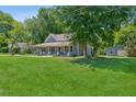 Spacious lawn and mature trees surrounding this charming home with a covered front porch, offering a serene outdoor setting at 1382 6Th Ave, Auburn, GA 30011