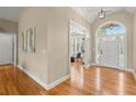 Bright and airy foyer with hardwood floors and a transom window above the front door at 411 Hickory Fairway Ct, Woodstock, GA 30188