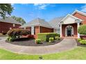 Beautiful brick home with manicured landscaping and a curved sidewalk to the front door at 411 Hickory Fairway Ct, Woodstock, GA 30188