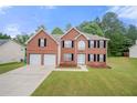 Charming two-story brick home with a well-maintained lawn and a two-car garage at 1486 Rogers Crossing Dr, Lithonia, GA 30058