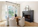 Dining room boasting a modern chandelier, black fireplace, and bright, natural light at 77 Delmont Ne Dr, Atlanta, GA 30305