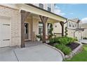Inviting front porch with brick supports, stylish seating, and decorative landscaping at 2445 Hidden Creek Rd, Kennesaw, GA 30152