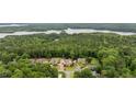 Panoramic aerial view of an estate nestled in a lush, wooded area near a tranquil lake at 615 Lovinggood Trl, Woodstock, GA 30189