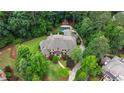 Aerial view of an estate featuring a large brick home, lush landscaping, swimming pool, pool house, and mature trees at 816 Blackfoot Trl, Suwanee, GA 30024