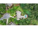 An aerial view of a luxurious home with a pool, surrounded by a lush green lawn and tall trees at 816 Blackfoot Trl, Suwanee, GA 30024