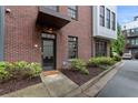 Front door of a brick condo building with dark awning and manicured landscaping at 1300 Dekalb Ne Ave # 711, Atlanta, GA 30307