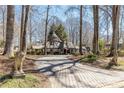Paver driveway approach to a charming Tudor-style home with mature trees and lion statues at 4210 Gatewood Ln, Peachtree Corners, GA 30097