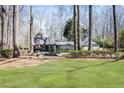 Spacious front lawn with mature trees and a charming water fountain at this Tudor-style home at 4210 Gatewood Ln, Peachtree Corners, GA 30097