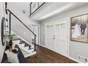 Bright entryway with hardwood floors, a modern staircase, and a stylish front door at 4733 Eidson Road, Dunwoody, GA 30360