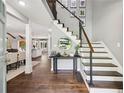 Inviting foyer boasts hardwood floors, a modern staircase, and views of the living and dining areas at 4733 Eidson Road, Dunwoody, GA 30360