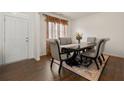 Elegant dining room featuring a dark wood table, upholstered chairs, and hardwood floors with a decorative rug at 105 Arbor Creek Trl, Dallas, GA 30157