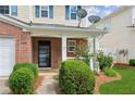 Inviting front porch with brick accents, manicured bushes, and lovely landscaping at 3698 Roseman Lndg, Cumming, GA 30040