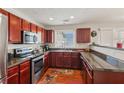 Well-lit kitchen featuring dark wood cabinets, granite countertops, and stainless steel appliances at 3698 Roseman Lndg, Cumming, GA 30040