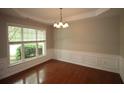 Dining room featuring hardwood floors, a large window, decorative molding, and a chandelier at 942 Idlewood Dr, Canton, GA 30115