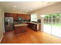 Open kitchen with stainless steel appliances, dark cabinets, island, and sliding glass doors to the outside at 942 Idlewood Dr, Canton, GA 30115