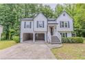 Two-story home with an open car port, white siding, and dark shutters, surrounded by lush greenery at 159 Aztec Se Way, Acworth, GA 30102