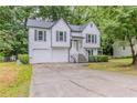 Two-story home with white siding, dark shutters, attached garage and surrounded by lush greenery at 159 Aztec Se Way, Acworth, GA 30102