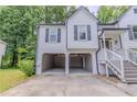 Two-story home with an open car port, white siding, and dark shutters, surrounded by lush greenery at 159 Aztec Se Way, Acworth, GA 30102