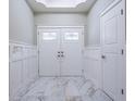 Inviting foyer featuring elegant double doors, wainscoting, and marble floors at 3924 Ashford Dunwoody Road Northeast Ne Rd, Atlanta, GA 30319