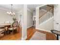 Elegant foyer with hardwood floors, chandelier, staircase, and dining area with an adjacent kitchen at 3937 Covey Flush Sw Ct # 25, Smyrna, GA 30082