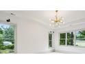 Bright room features a modern light fixture, white walls, and large windows offering views of the surrounding greenery at 2760 Fraser Se St, Smyrna, GA 30080