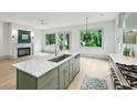 Bright, modern kitchen features an island, marble countertops, stainless steel appliances, and view to fireplace and backyard at 2760 Fraser Se St, Smyrna, GA 30080
