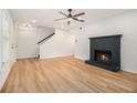 Spacious living room with wood floors, a cozy fireplace, and a modern ceiling fan at 657 Stratford Green Way, Avondale Estates, GA 30002