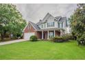 Traditional two-story home with brick and siding exterior, manicured lawn, and inviting front porch at 806 Chelsea Wood Ct, Stockbridge, GA 30281
