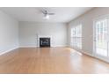 A well-lit living room with light hardwood flooring and a classic fireplace, offering a spacious and inviting atmosphere at 806 Chelsea Wood Ct, Stockbridge, GA 30281