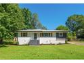 Inviting single-story home with landscaped front yard, white painted brick and wood accent shutters at 941 Shirley Se St, Smyrna, GA 30082
