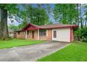 Quaint single-story brick home featuring a well-kept lawn and a paved driveway at 3047 Hudson Ct, Decatur, GA 30033