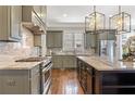 The kitchen features stainless steel appliances, grey cabinets, an island, and modern lighting at 3834 Chamblee Dunwoody Rd, Atlanta, GA 30341