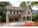 An attractive two-story home displays a brick and siding exterior with a two-car garage below a metal awning at 1115 Ralph Ne Rd, Atlanta, GA 30324