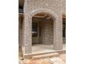 Arched brick entryway shows a covered porch leading to the front door with a glass side panel at 1115 Ralph Ne Rd, Atlanta, GA 30324