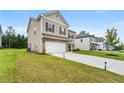 Side view of a two-story home, showcasing a well-manicured lawn and long driveway at 228 Whitneys Way, Dallas, GA 30157