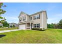 Inviting two-story home featuring neutral siding, brick accents, a two-car garage, and landscaped lawn at 228 Whitneys Way, Dallas, GA 30157