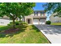 Inviting two-story home with brick accents, attached garage, and tree in the yard at 3524 Preserve Run Trl, Loganville, GA 30052