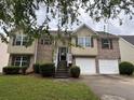 Inviting two-story home with brick accents, a two-car garage, and a landscaped front yard at 4069 Savannah Ridge Ct, Loganville, GA 30052
